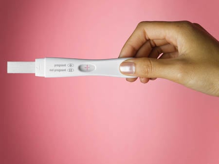 Woman's hand holding pregnancy test