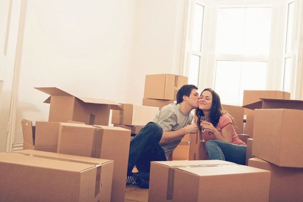 Romantic couple with champagne and moving boxes