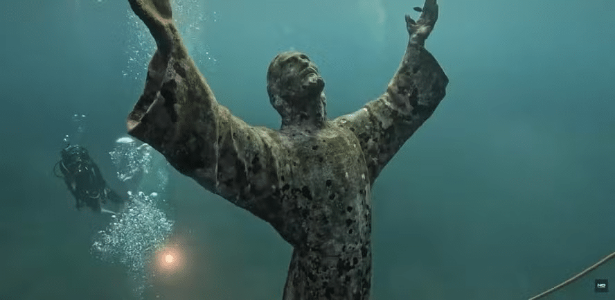 Estátua submersa de Cristo é limpa por mergulhadores no